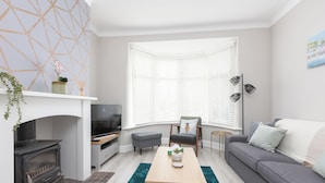 A modern living room with a fireplace, a sofa, a coffee table, and a television. - Ansdell House, Ansdell Road (Blackpool)