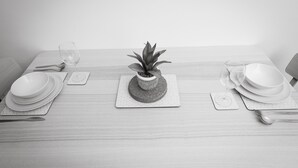 A neatly set dining table with plates, cutlery, and a potted plant. - Ansdell House, Ansdell Road (Blackpool)