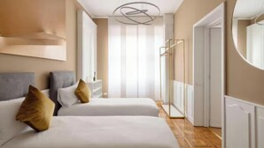 Ein Hotelzimmer mit zwei Betten, einem großen Spiegel, einem Kleiderschrank und einer Dusche.
