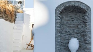 Een interieur met witte muren, een stenen boog en een witte vaas.