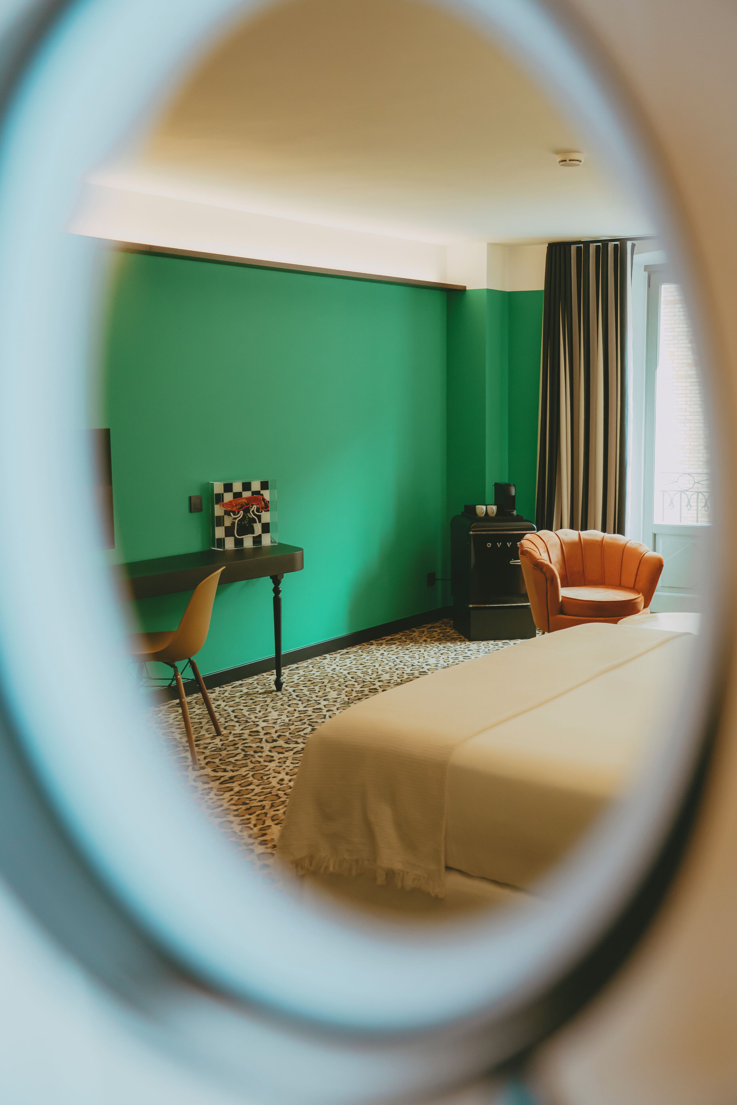Una habitación con cama, silla, escritorio y cómoda.