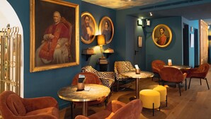 A room with a large portrait, multiple round tables, and patterned chairs. - Hotel Divino by Fimedhotels (Figueres)