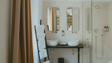 A bathroom with two sinks, a shower, and a checkered floor.