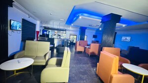 A bar area with seating and a television screen. - Novatel Hotel (Lekki)