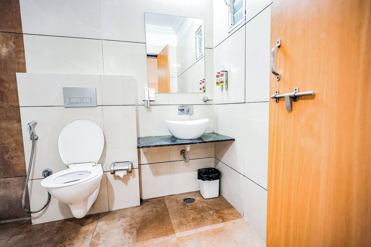 A modern bathroom with a toilet, sink, and mirror.
