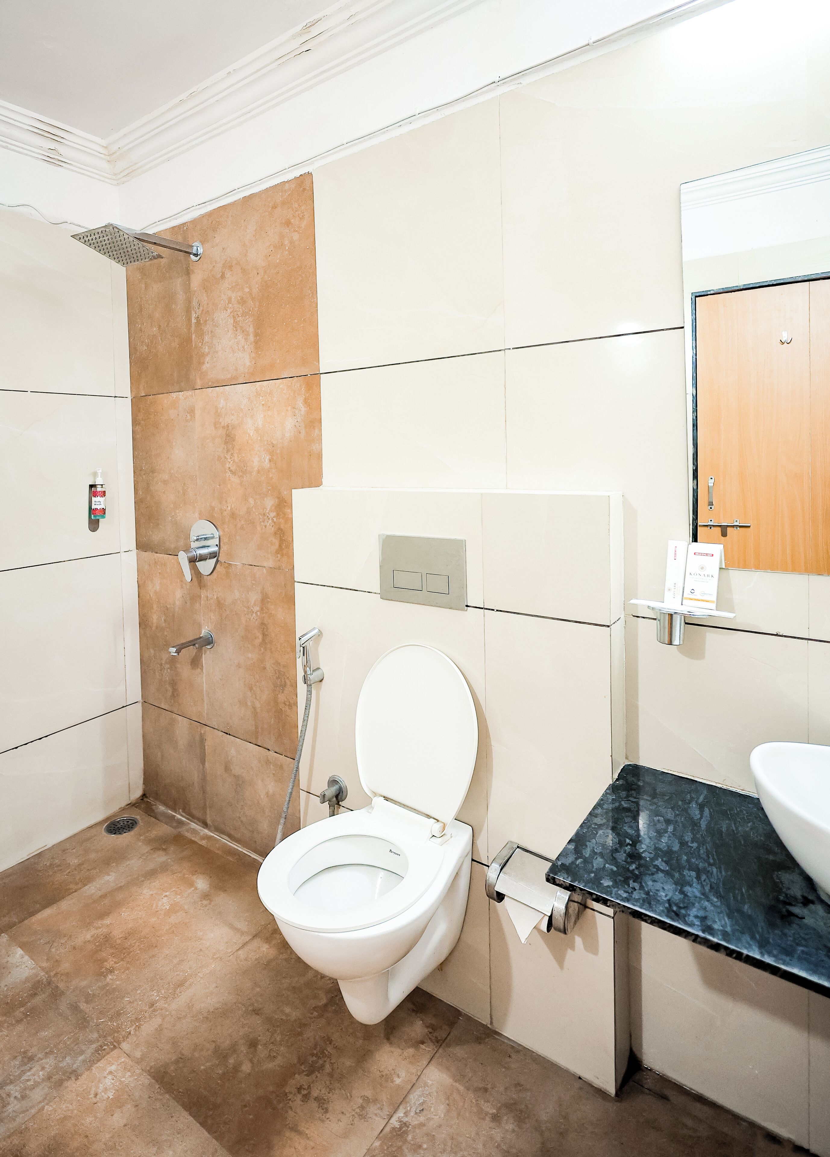 A bathroom with a toilet, shower, and sink.