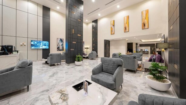 A modern lobby with grey sofas, a marble coffee table, and artwork on the walls. - Garden Millennium Hotel - Al-Salamah (Jeddah)