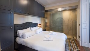 A hotel room with a large bed, dark wooden wardrobe, and a wall mural of a cityscape. - Independence Olive- 1 Bedroom - Square SEA View (Valletta)