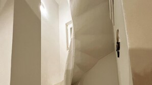 A narrow staircase with white walls and a wooden floor, leading to a higher level. - Local Living 2BR 2BA With Patio - Duplex Apartment (Valletta)