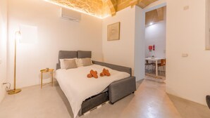 A modern bedroom with a bed, bedside table, and a lamp. - Charming 1BR Apartment - Center Of Valletta (Valletta)