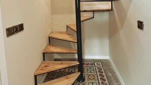 A spiral staircase with wooden steps and black metal railings. - Local Gem Spacious 2BR 2BA Duplex Apartment (Valletta)
