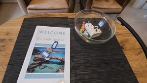 Un felpudo con un llavero y una cúpula de vidrio que contiene objetos decorativos sobre una mesa redonda.