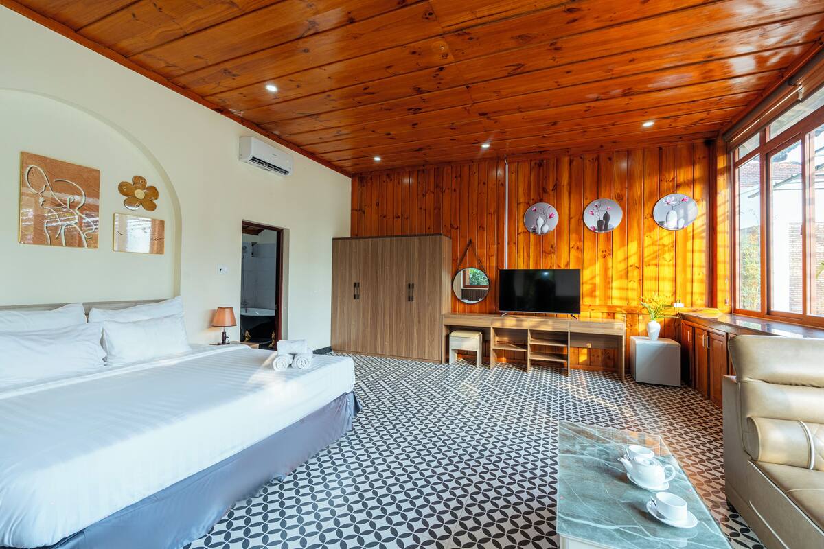 Une chambre d’hôtel avec un lit, un bureau, une télévision et un canapé.
