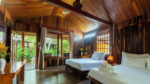 A wooden room with two beds, a desk, and a window overlooking greenery. - Herbal Resort (Phu Quoc)