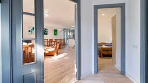 Un intérieur moderne avec un plancher en bois, un coin repas comprenant des chaises et une table, et un lit dans une pièce séparée.
