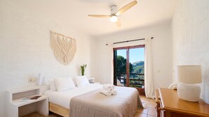 A bedroom with a bed, a nightstand, a dresser, a ceiling fan, and a view of the outdoors through a window. - Serena in Lloret de Mar (Lloret de Mar)