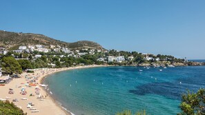 A coastal town with a sandy beach, clear blue waters, and buildings on a hillside. - Vila Lina in Lloret de Mar (Lloret de Mar)