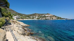 A coastal town with rocky shores, clear blue waters, and buildings on a hillside. - Vila Lina in Lloret de Mar (Lloret de Mar)