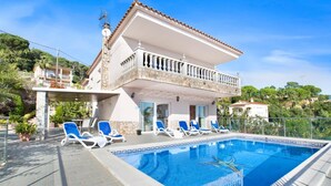Une maison à deux étages avec une piscine, un balcon et un jardin.