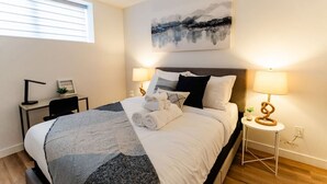 Une chambre bien rangée, avec un lit, des tables de chevet et un bureau.