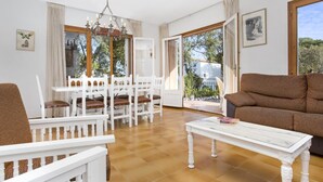 A spacious living room with a dining area, large windows, and a balcony. - Can Benet 1 in Calella de Palafrugell (Palafrugell)