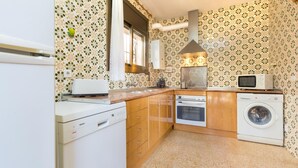 Una cocina compacta con lavavajillas Bosch, horno, microondas y lavadora.