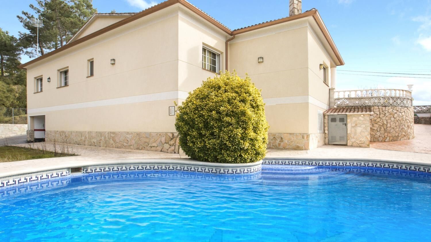 A two-story house with a swimming pool in front.