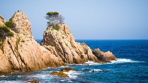 Paisatge costaner amb penya-segats rocosos i mar blau clar.