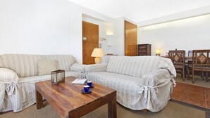 Un salon avec un canapé, une table basse en bois et une lampe.