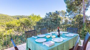 Enjoy al fresco dining on the terrace with a table set for four, surrounded by comfortable chairs and a beautiful view.