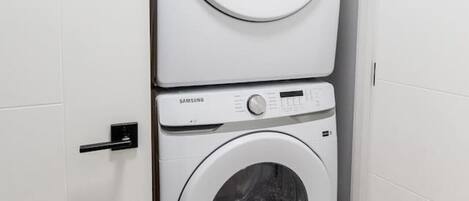 Una bugaderia petita i blanca amb dues rentadores superposades.