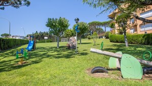 A playground with swings, a slide, and a seesaw. - Illa 23 in Calella de Palafrugell (Palafrugell)