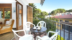 A balcony with a table and chairs, a wooden chair, and a view of the neighborhood. - Bravo in Llafranc With 3 Bedrooms and 1 Bathrooms (Palafrugell)