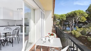 A balcony with a dining table, chairs, and a flower vase. - Ancora 15 B-2 in Llafranc (Palafrugell)