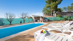 A swimming pool with lounge chairs and a small building with a striped awning. - Alonso in Vidreres With 4 Bedrooms and 1 Bathrooms (Vidreres)