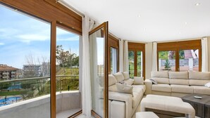 A spacious living room with a large window, a sofa set, and a view of a swimming pool. - Paulina in Lloret de Mar (Lloret de Mar)