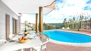 A poolside area with a dining table set for two, surrounded by white chairs. - Paulina in Lloret de Mar (Lloret de Mar)