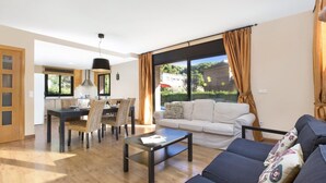 A modern living room with a sofa, coffee table, and dining area with chairs and a table. - Llevant 2 in Lloret de Mar (Lloret de Mar)