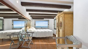 Un dormitorio con dos camas, un armario de madera y un banco.