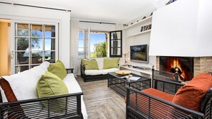 A modern living room with a fireplace, a sofa, a coffee table, and a TV. - Ses Brises 31 in Llafranc (Palafrugell)