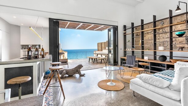 A modern living room with a view of the sea, a dining area, and a kitchen with bar stools. - Mirador in Llafranc With 4 Bedrooms and 4 Bathrooms (Palafrugell)