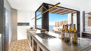 A modern kitchen with a large island, a built-in oven, and a wine rack. - Mirador in Llafranc With 4 Bedrooms and 4 Bathrooms (Palafrugell)