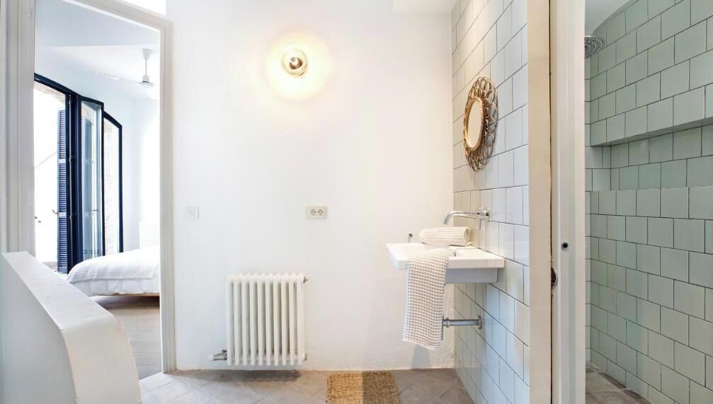 Une salle de bain moderne avec un lavabo blanc, un porte-serviettes et un radiateur.