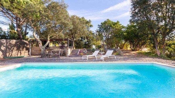A swimming pool with lounge chairs and a pergola, surrounded by trees. - Castanyer in Lloret de Mar (Lloret de Mar)