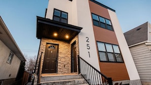 A modern two-story building with a stone facade, a dark brown door, and the number 251 displayed on the wall. - Cozy Winnipeg Getaway - Near The Forks & Hospital (Winnipeg)
