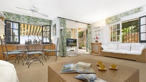 A spacious living area with a sofa, coffee table, and dining setup. - Ses Brises 28 in Llafranc (Palafrugell)