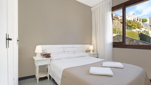 Una habitación de hotel con cama, escritorio y ventana con vistas a edificios.