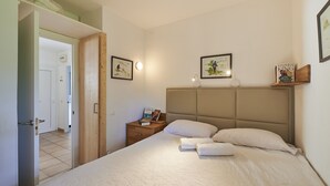 A bedroom with a large bed, a nightstand, a wooden headboard, and framed pictures on the wall. - Cliper C 3 in Llafranc (Palafrugell)