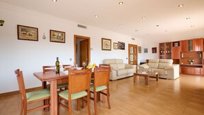 Un grand espace de vie comprenant une table à manger, des chaises, un canapé et un meuble.