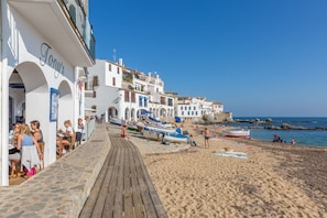 A coastal promenade with a wooden walkway, beachside seating, and boats. - Ancora 04 in Llafranc (Palafrugell)